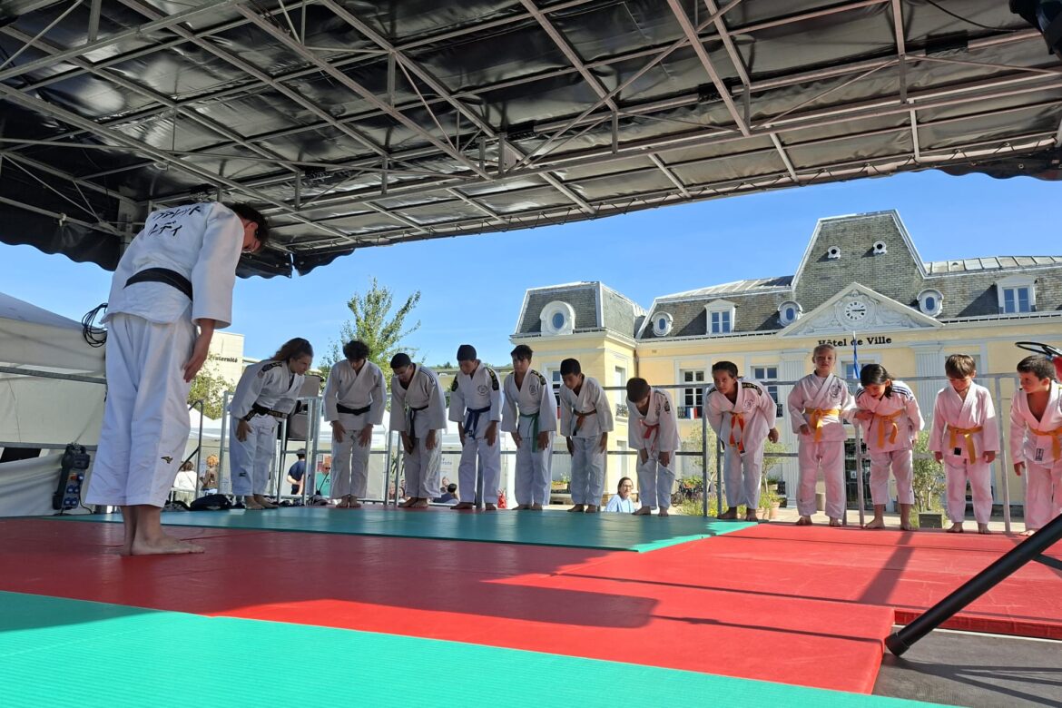 Démonstration de judo par les judokas du club EG Judo lors du Forum des Associations de Gagny, avec Ruddy Vallet orchestrant la prestation sur le podium, entouré des participants et des parents venus soutenir le club